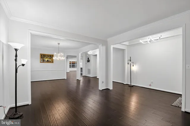 a view of a big room with wooden floor and windows