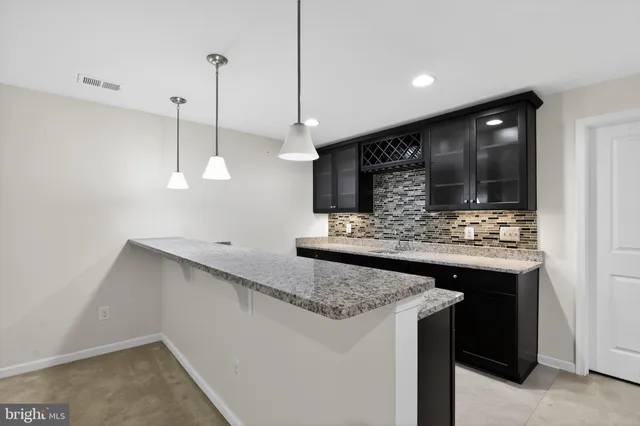 a kitchen with stainless steel appliances granite countertop a sink and a refrigerator