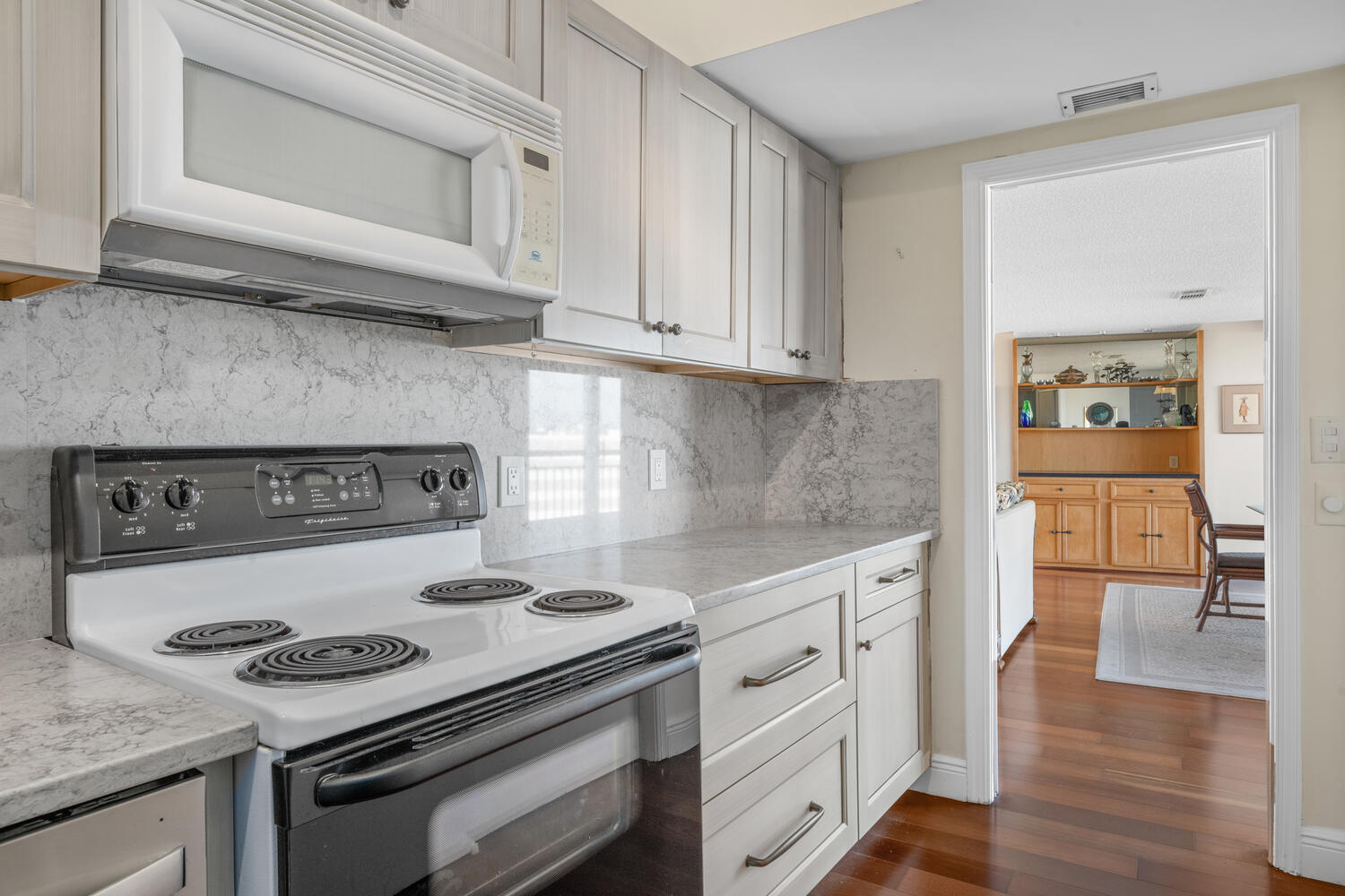 2780 South Ocean Boulevard, Unit 612 Palm Beach, FL 33480 - Photo 25 of 57 a kitchen with granite countertop a stove and a wooden cabinets