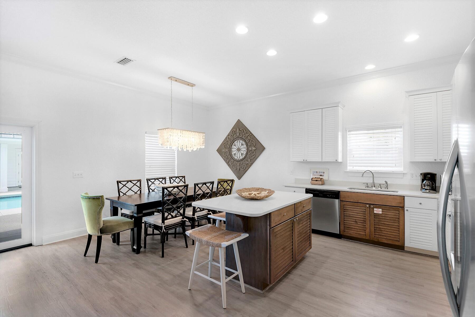 80 Pompano Street Destin, FL 32541 - Photo 16 of 71 a kitchen with a stove a sink a dining table and chairs