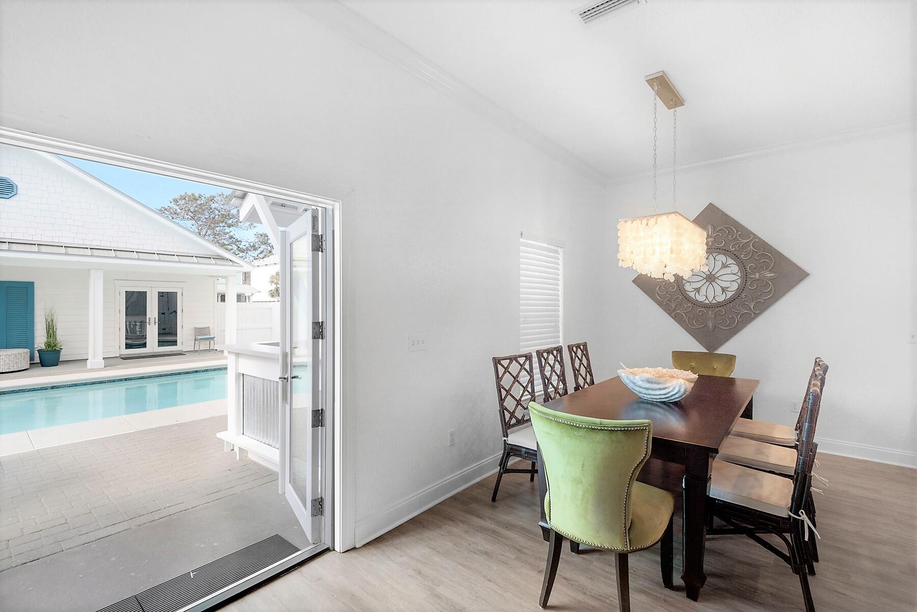 80 Pompano Street Destin, FL 32541 - Photo 18 of 71 a view of a dining room with furniture a chandelier and wooden floor