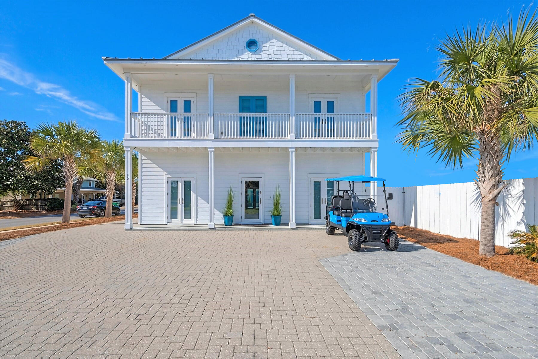 80 Pompano Street Destin, FL 32541 - Photo 2 of 71 a front view of a house with outdoor seating and a yard