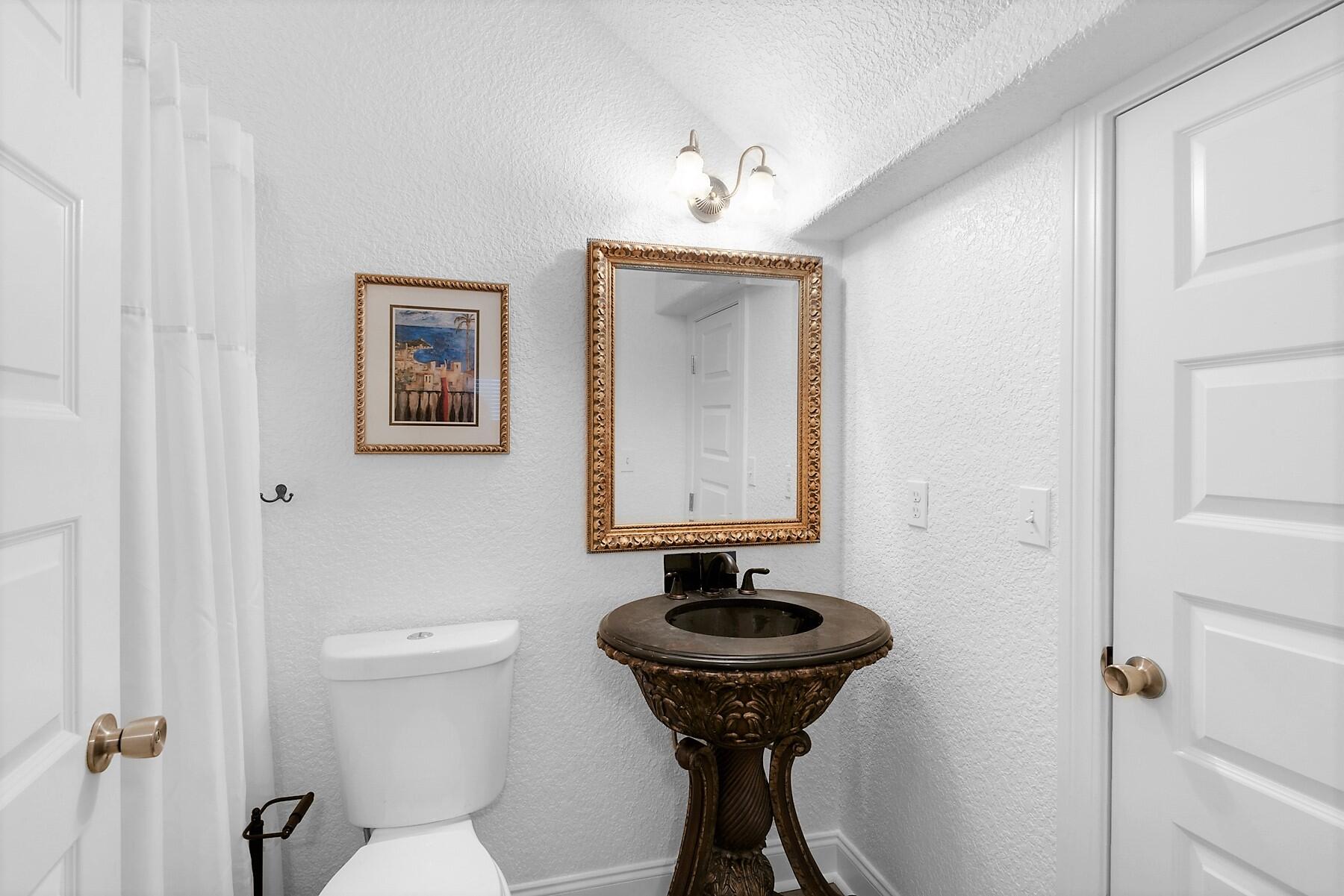 80 Pompano Street Destin, FL 32541 - Photo 26 of 71 a bathroom with a toilet sink and mirror
