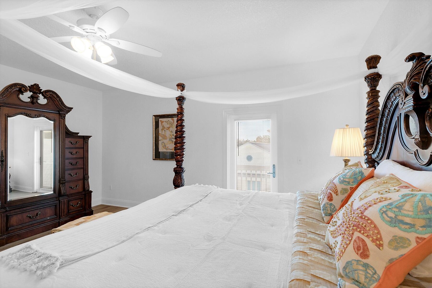 80 Pompano Street Destin, FL 32541 - Photo 29 of 71 a bedroom with a bed and a chandelier