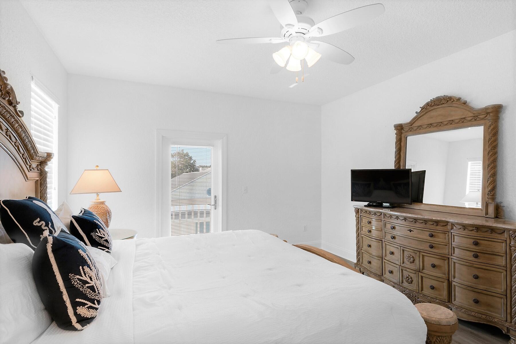 80 Pompano Street Destin, FL 32541 - Photo 33 of 71 a bedroom with a bed and a flat tv screen on dresser