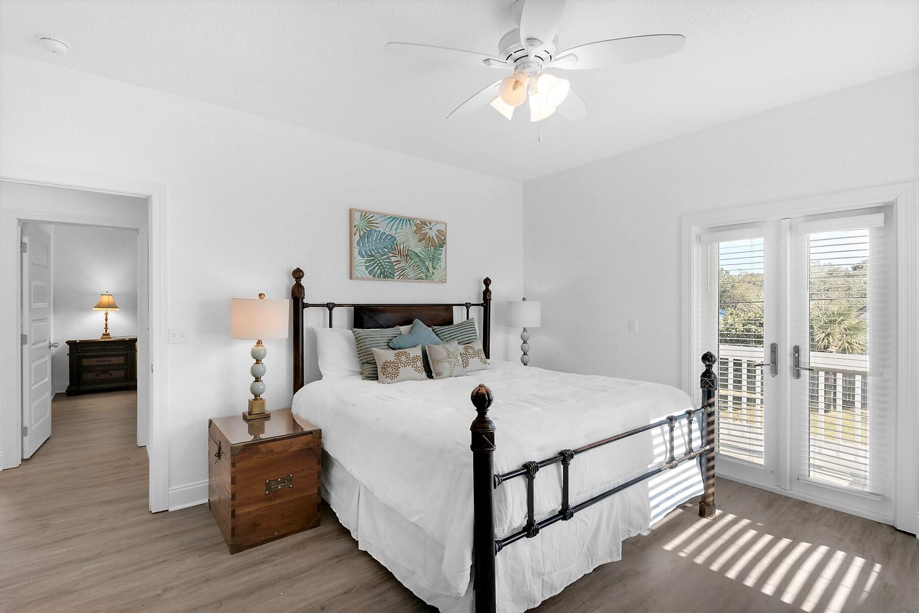 80 Pompano Street Destin, FL 32541 - Photo 40 of 71 a bedroom with a large bed and a chandelier