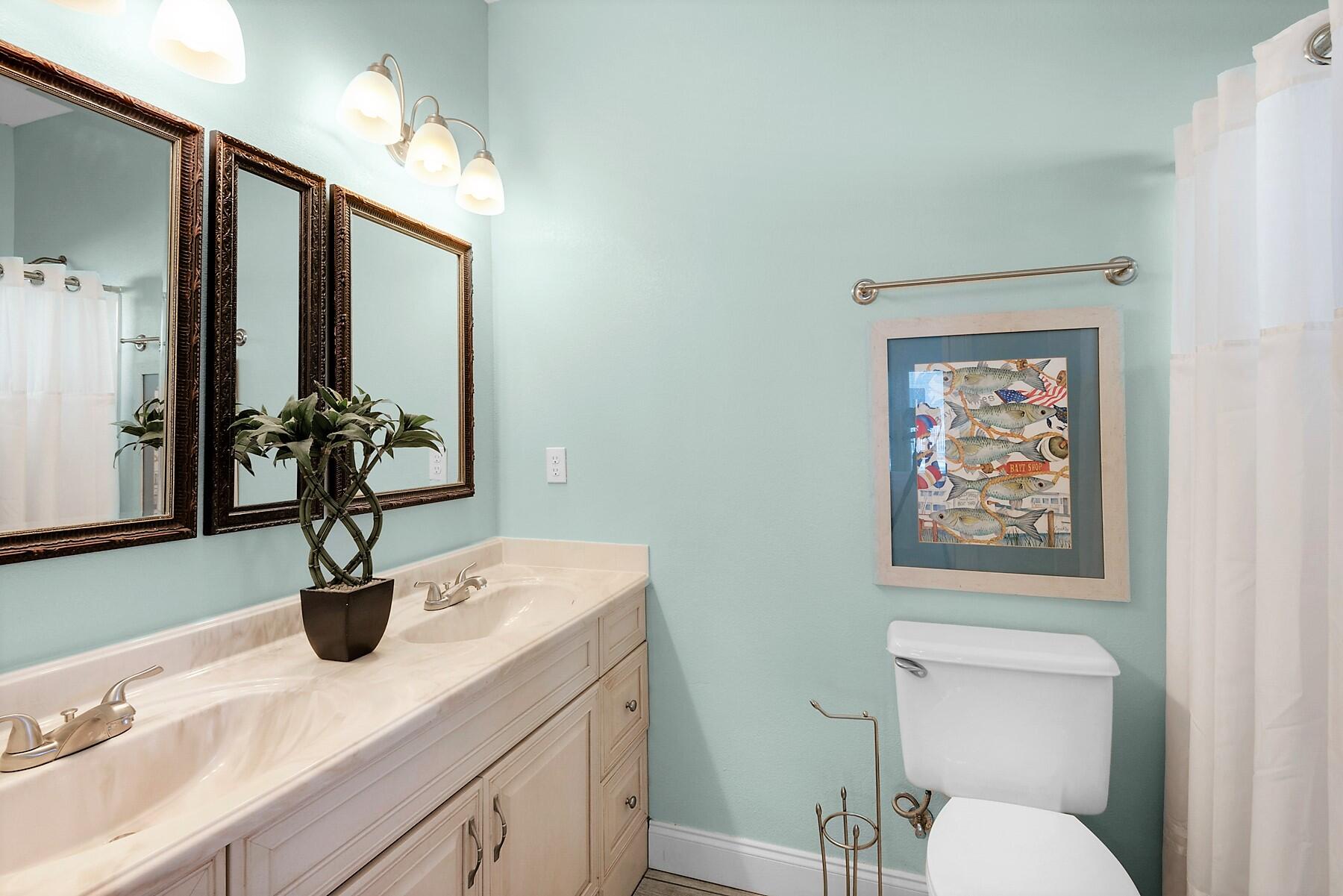 80 Pompano Street Destin, FL 32541 - Photo 52 of 71 a bathroom with a sink a toilet and mirror