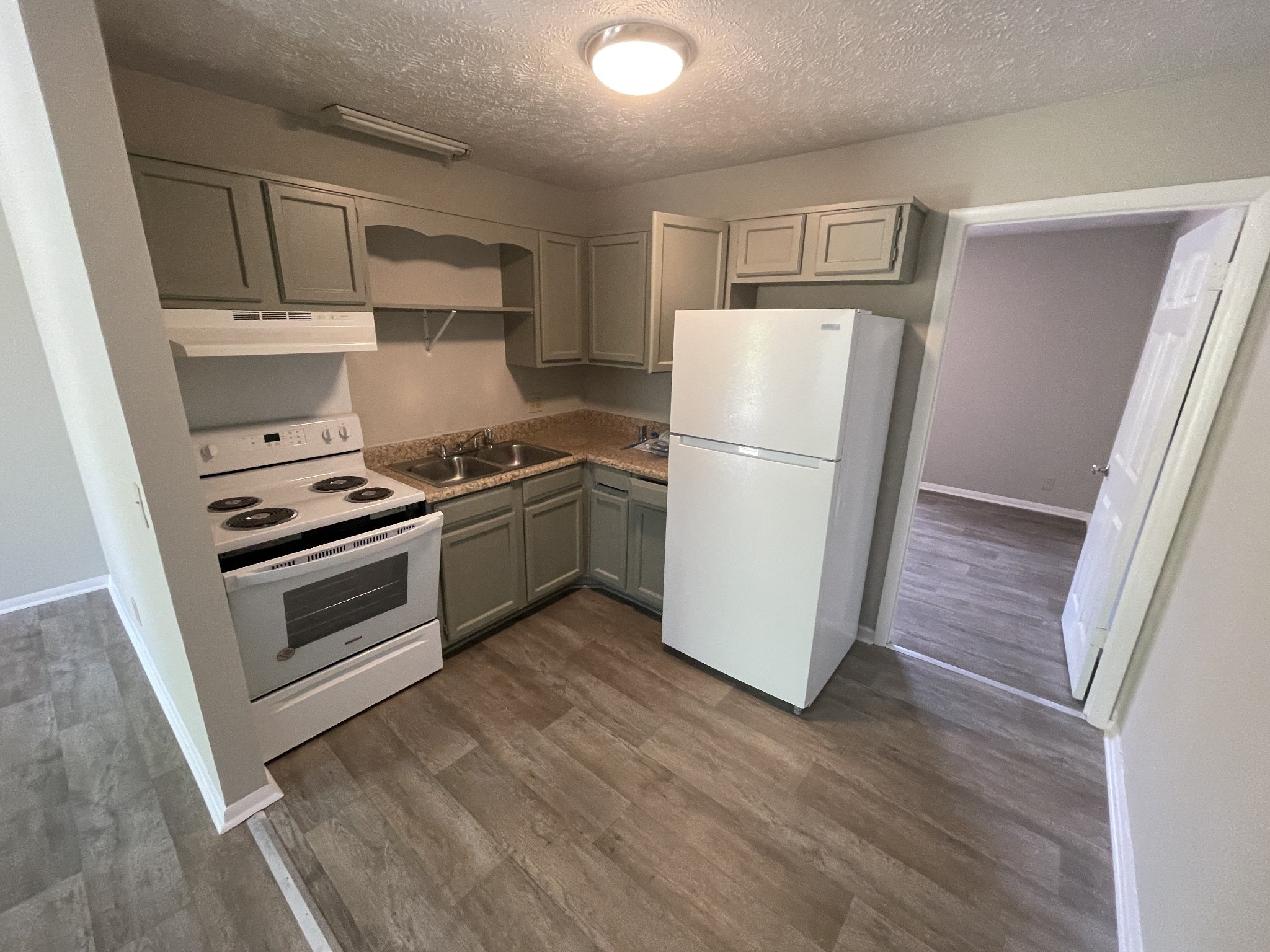209 East Webster Street Madison, TN 37115 - Photo 5 of 33 a kitchen with a refrigerator a stove top oven and wooden floor