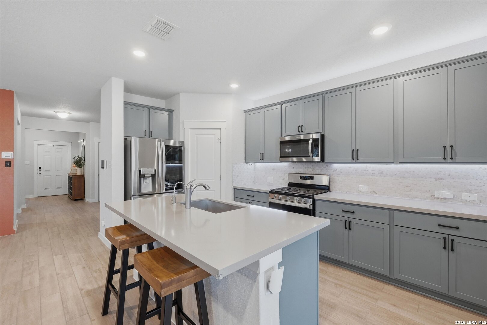 10776 Rosalina Loop Converse, TX 78109 - Photo 9 of 31 a kitchen with a sink a stove a refrigerator and white cabinets