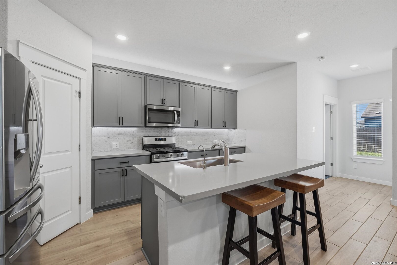 10776 Rosalina Loop Converse, TX 78109 - Photo 10 of 31 a kitchen with stainless steel appliances a stove a sink refrigerator and a refrigerator with wooden floor