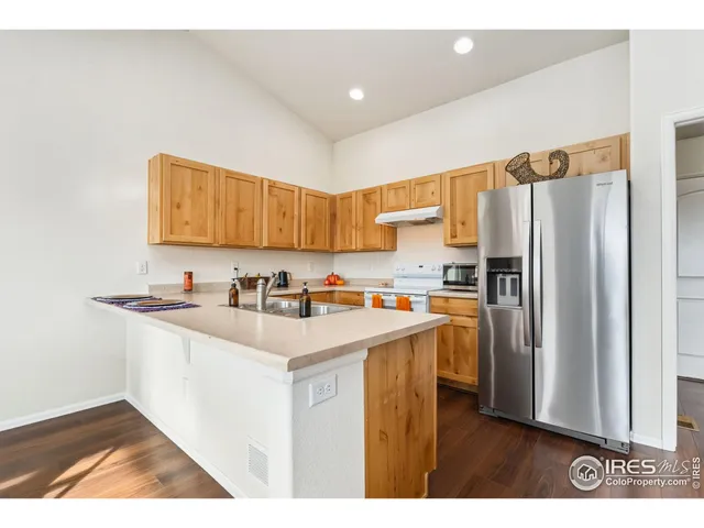 a kitchen with stainless steel appliances granite countertop a refrigerator a sink and a stove