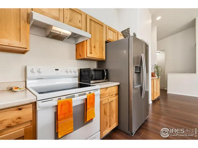 a kitchen with stainless steel appliances granite countertop a refrigerator a stove and a sink