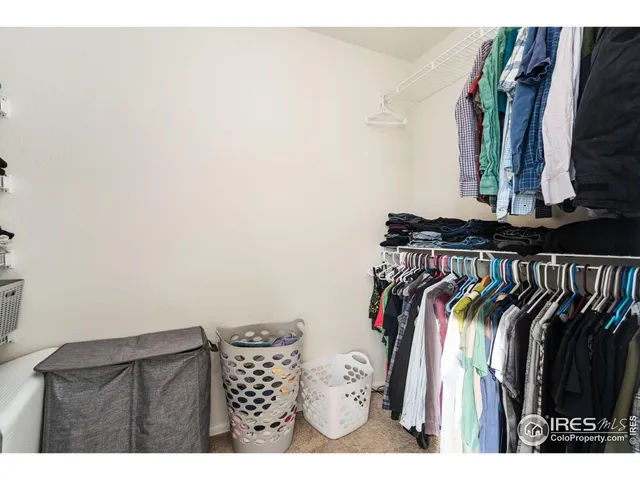 a view of walk in closet with clothes and shoes