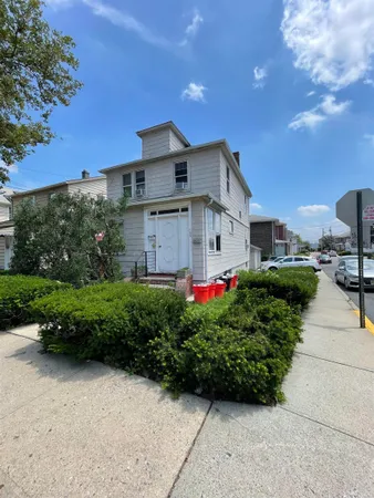 a front view of a house with a yard and potted plants