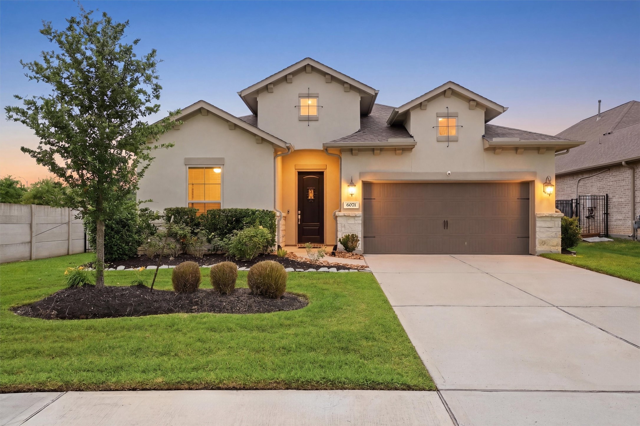 6071 Windward Falls Way Porter, TX 77365 - Photo 1 of 33 Charming single-story home with a modern facade, featuring a spacious two-car garage and well-manicured front yard. The exterior is accentuated by neat landscaping and warm exterior lighting, creating an inviting atmosphere.