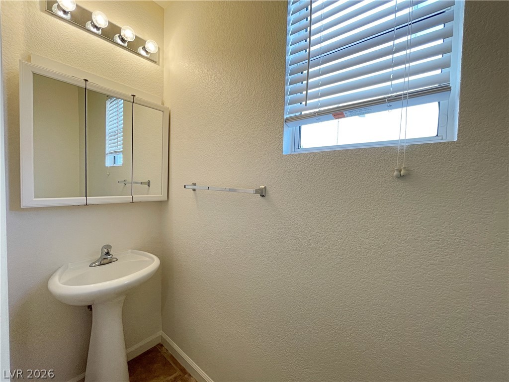 691 Principle Point Avenue Henderson, NV 89012 - Photo 14 of 30 A compact bathroom offers essential fixtures and a naturally illuminated window.