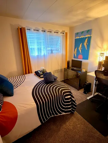 a bedroom with a bed and wooden floor