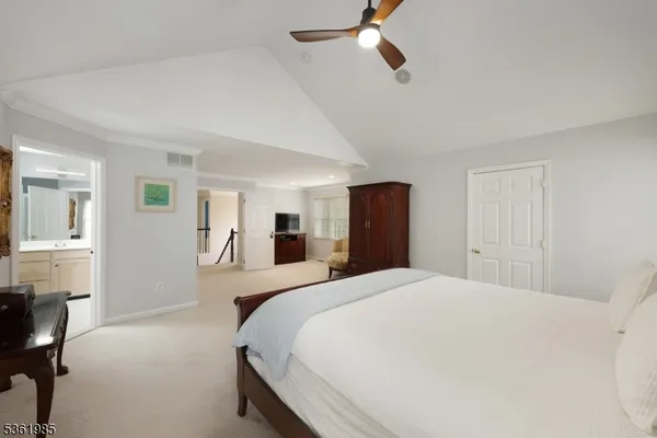 a bedroom with a large bed and a chandelier