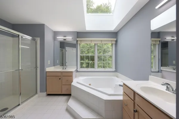 a bathroom with a tub sink and mirror