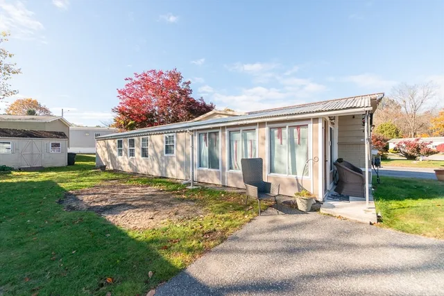 a view of a house with backyard and sitting area