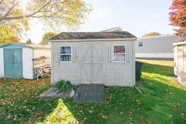 a view of a house with a yard plants and large tree
