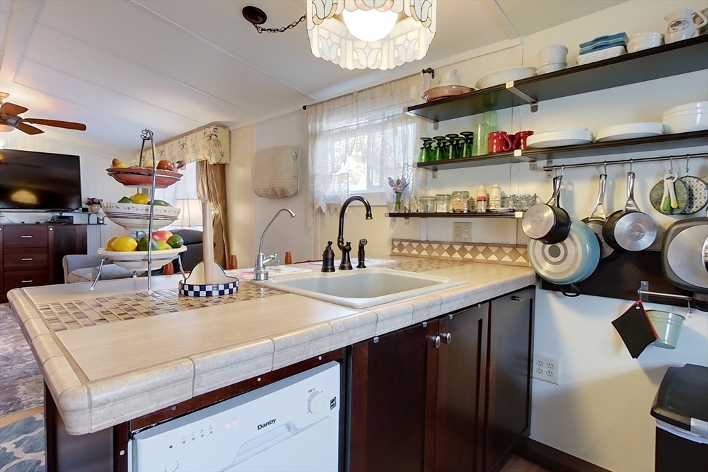 239 Ayer Road, Unit 46 Littleton, MA 01460 - Photo 3 of 28 a kitchen with a sink a stove and chairs with wooden floor