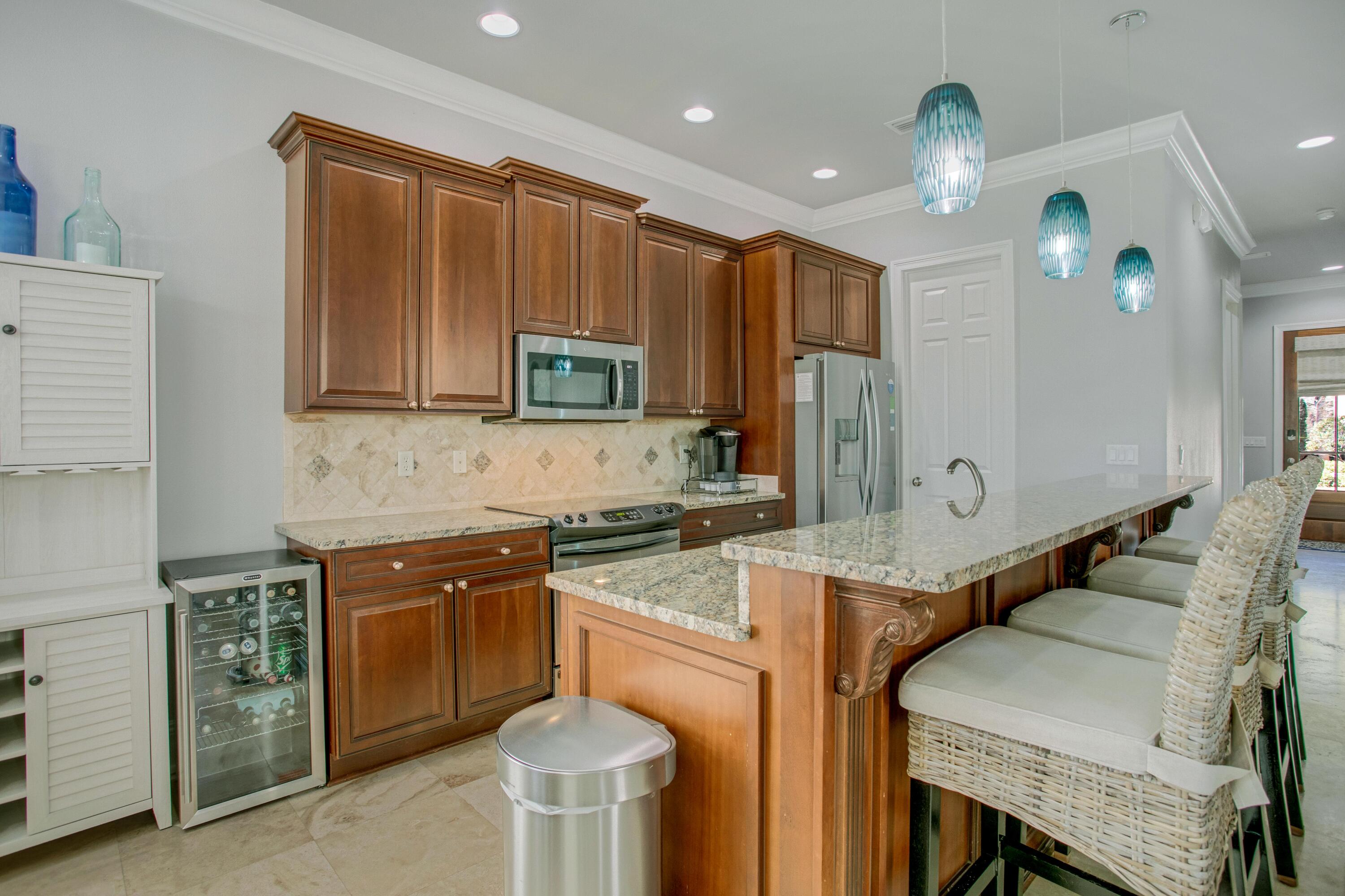 1893 Baytowne Loop Miramar Beach, FL 32550 - Photo 13 of 45 a kitchen with a stove a sink a microwave a refrigerator and cabinets