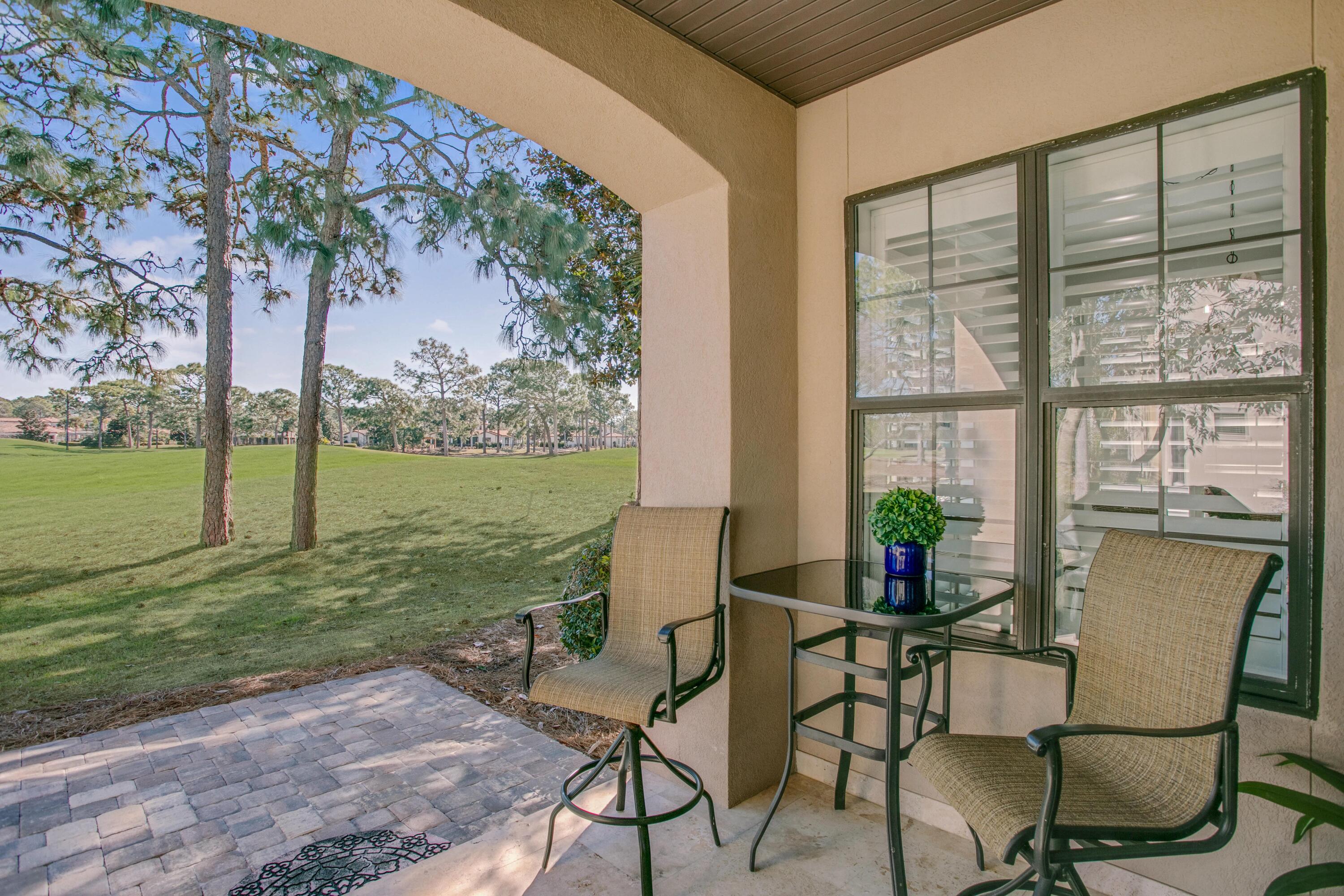 1893 Baytowne Loop Miramar Beach, FL 32550 - Photo 28 of 45 a view of a chairs and table in patio with a yard