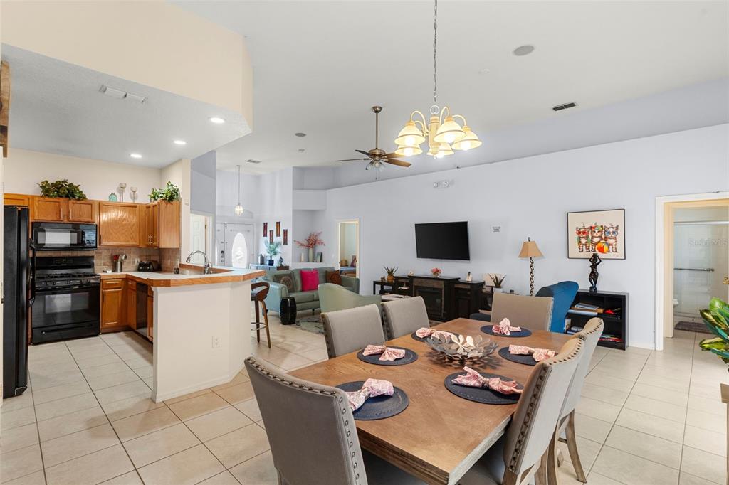 235 Hollinghead Loop Davenport, FL 33896 - Photo 13 of 30 a living room with kitchen island furniture and a flat screen tv