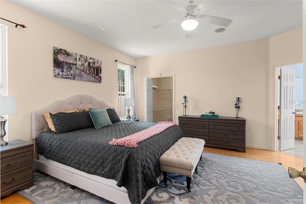 235 Hollinghead Loop Davenport, FL 33896 - Photo 14 of 30 a bedroom with a bed and wooden floor