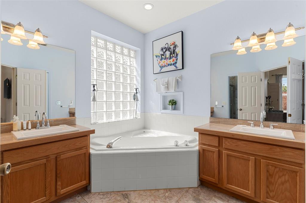 235 Hollinghead Loop Davenport, FL 33896 - Photo 17 of 30 a bathroom with a tub sink and mirror