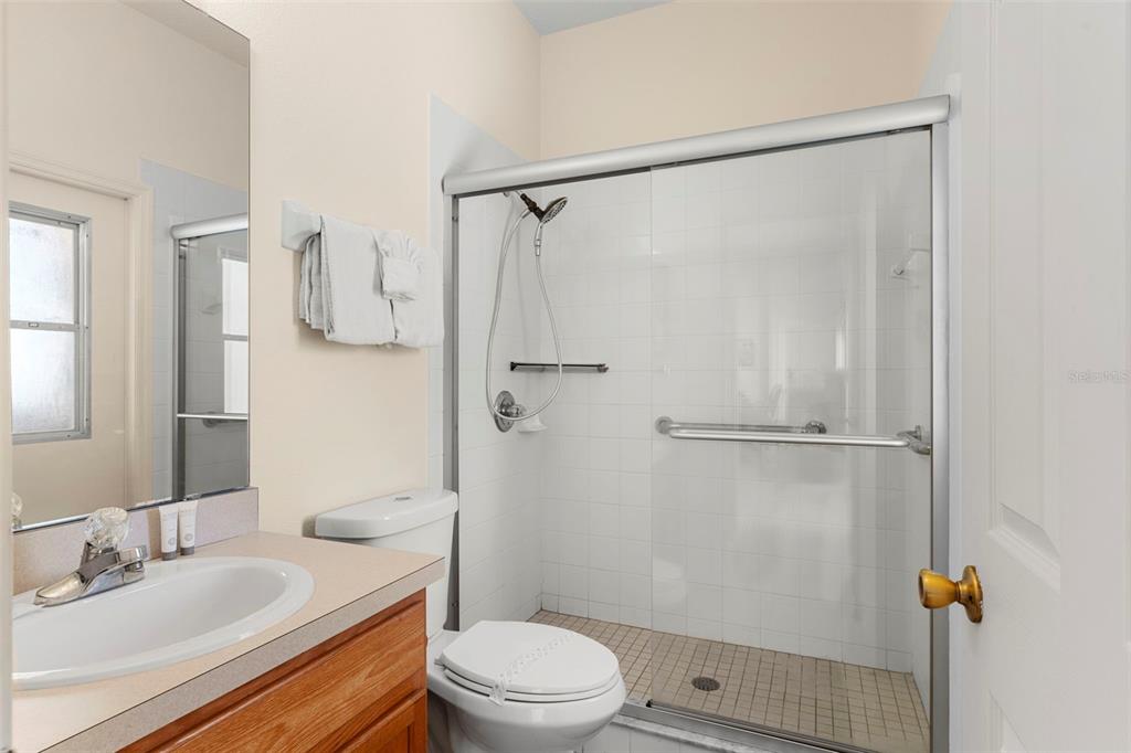 235 Hollinghead Loop Davenport, FL 33896 - Photo 24 of 30 a bathroom with a granite countertop sink toilet and shower