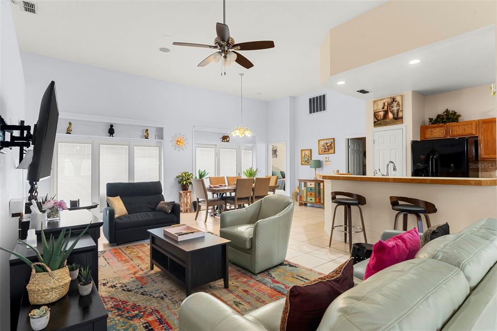 235 Hollinghead Loop Davenport, FL 33896 - Photo 8 of 30 a living room with furniture kitchen view and a flat screen tv