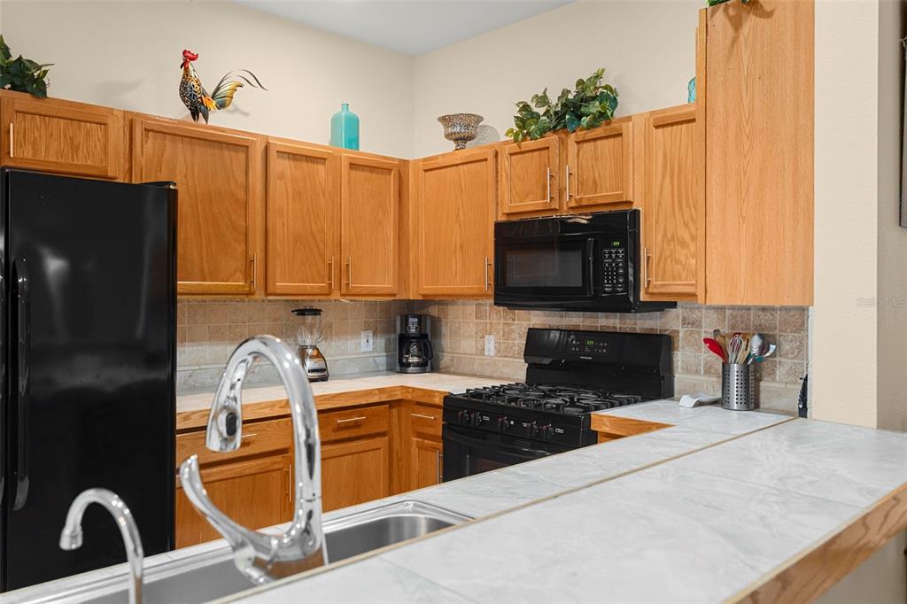 235 Hollinghead Loop Davenport, FL 33896 - Photo 10 of 30 a kitchen with stainless steel appliances granite countertop a refrigerator a stove top oven a sink and dishwasher