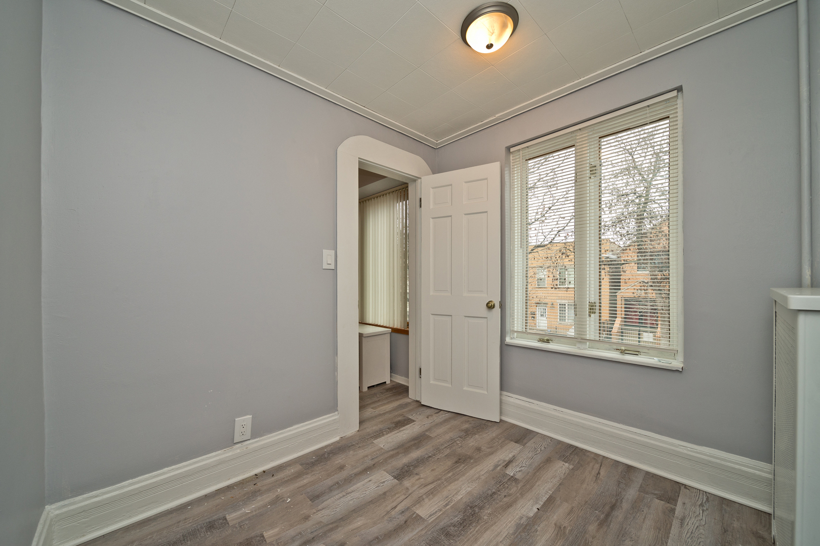 3641 South Union Avenue, Unit 2 Chicago, IL 60609 - Photo 9 of 13 a view of an empty room with wooden floor and a window