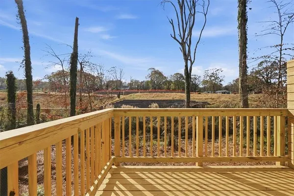a view of a balcony with wooden floor next to a yard
