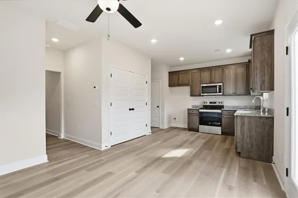 a kitchen with stainless steel appliances granite countertop a refrigerator a stove top oven a sink and dishwasher