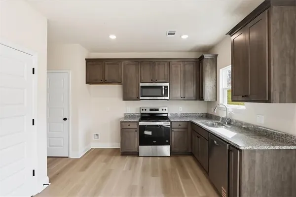 a kitchen with stainless steel appliances granite countertop a stove a sink and a refrigerator