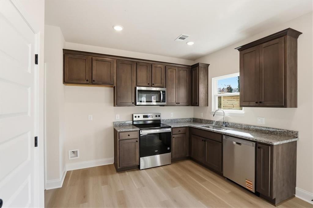 49 Wright Street, Unit 65 Lavonia, GA 30553 - Photo 6 of 17 a kitchen with stainless steel appliances granite countertop a sink stove and refrigerator