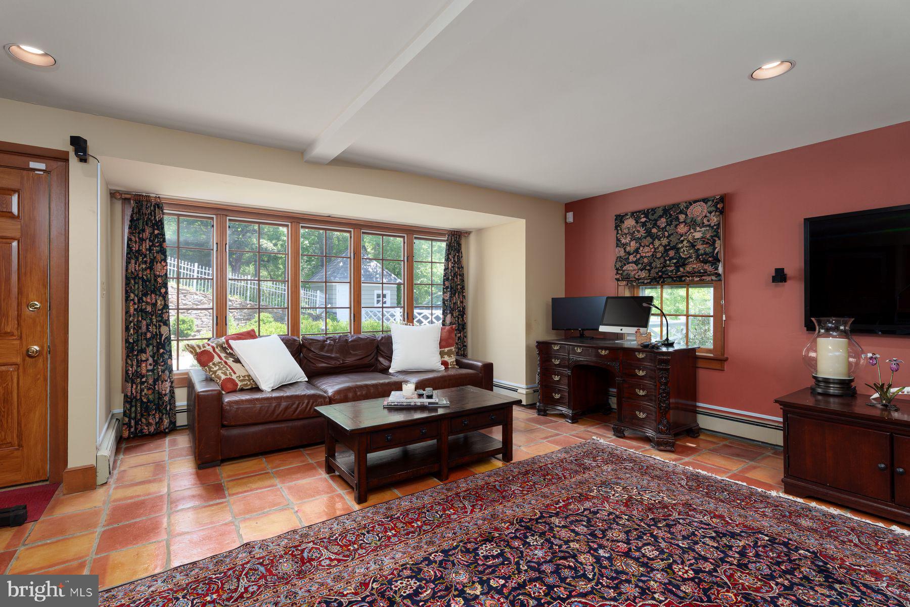 821 Pretty Brook Road Princeton, NJ 08540 - Photo 22 of 32 a living room with furniture a flat screen tv and a floor to ceiling window