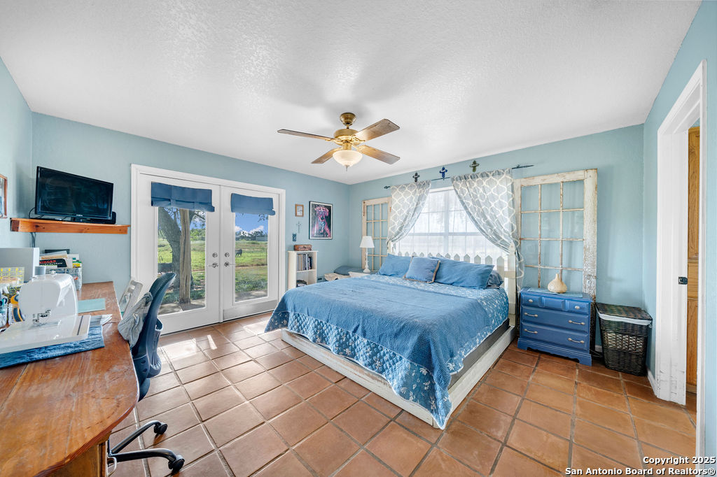 16020 Farm To Market Road 463 Lytle, TX 78052 - Photo 20 of 39 a bedroom with a bed and a large window