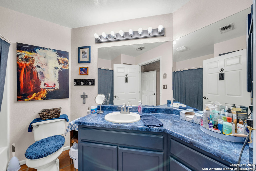 16020 Farm To Market Road 463 Lytle, TX 78052 - Photo 23 of 39 a bathroom with a granite countertop sink a toilet and a large mirror