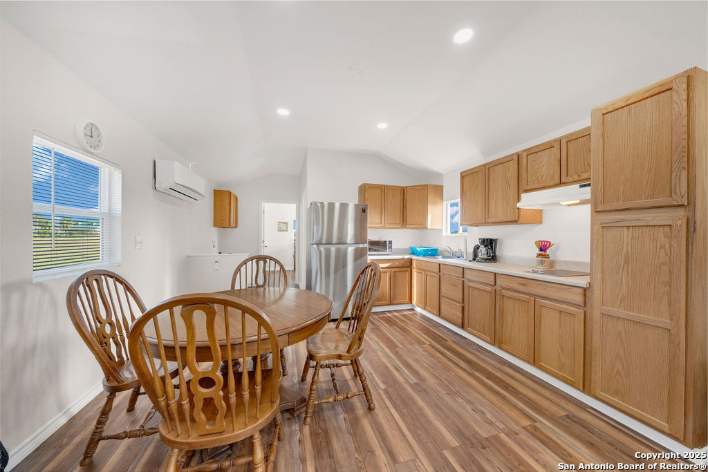 16020 Farm To Market Road 463 Lytle, TX 78052 - Photo 31 of 39 a kitchen with stainless steel appliances granite countertop a dining table chairs stove refrigerator and cabinets