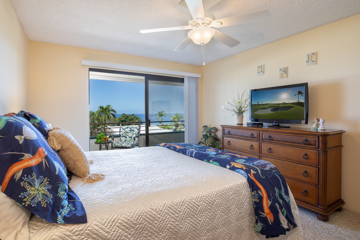 77-6585 Sea View Circle, Unit 104 Kailua-Kona, HI 96740 - Photo 13 of 23 a bedroom with a bed and a flat screen tv