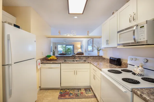 a kitchen with a white stove top oven and refrigerator