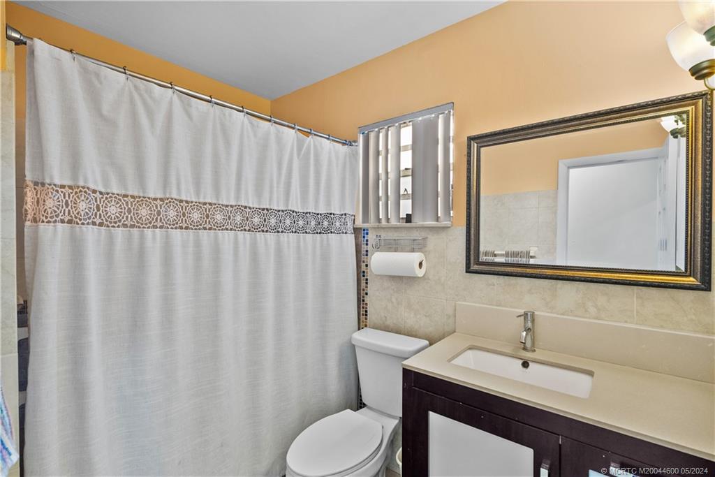 301 Lancaster Street Boca Raton, FL 33487 - Photo 12 of 20 a bathroom with a sink a toilet and mirror