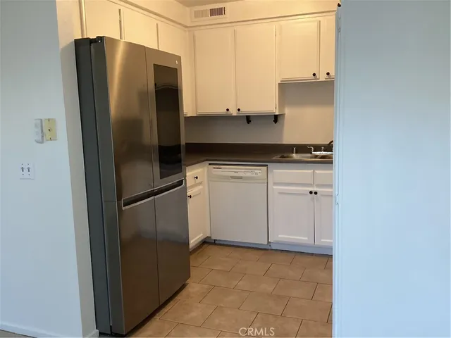 a kitchen with stainless steel appliances granite countertop white cabinets sink and granite counter tops