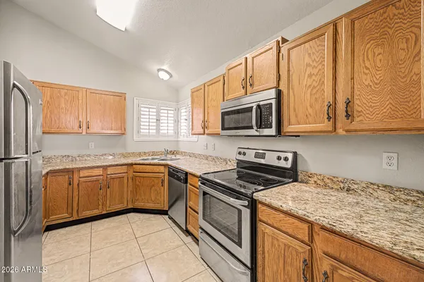 a kitchen with stainless steel appliances granite countertop a stove microwave and cabinets