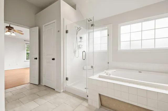 a spacious bathroom with a bathtub and shower