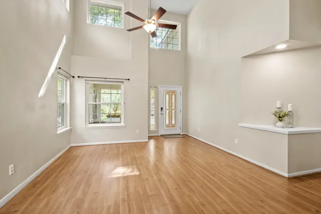 an empty room with wooden floor and windows